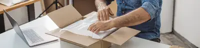 someone at their home office is preparing a package